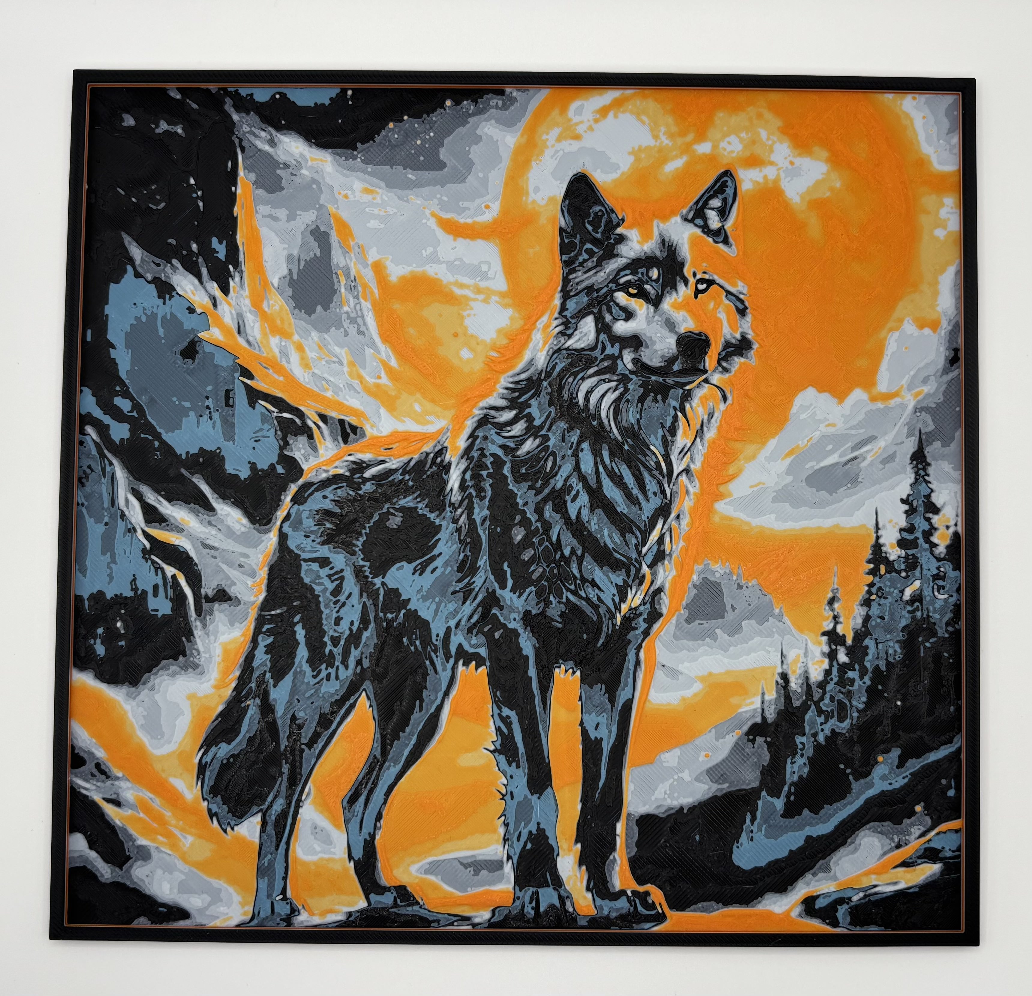 HueForge 3D printed wall art of a wolf standing against a bright orange moon and 			dramatic mountain background, stylized wildlife art print