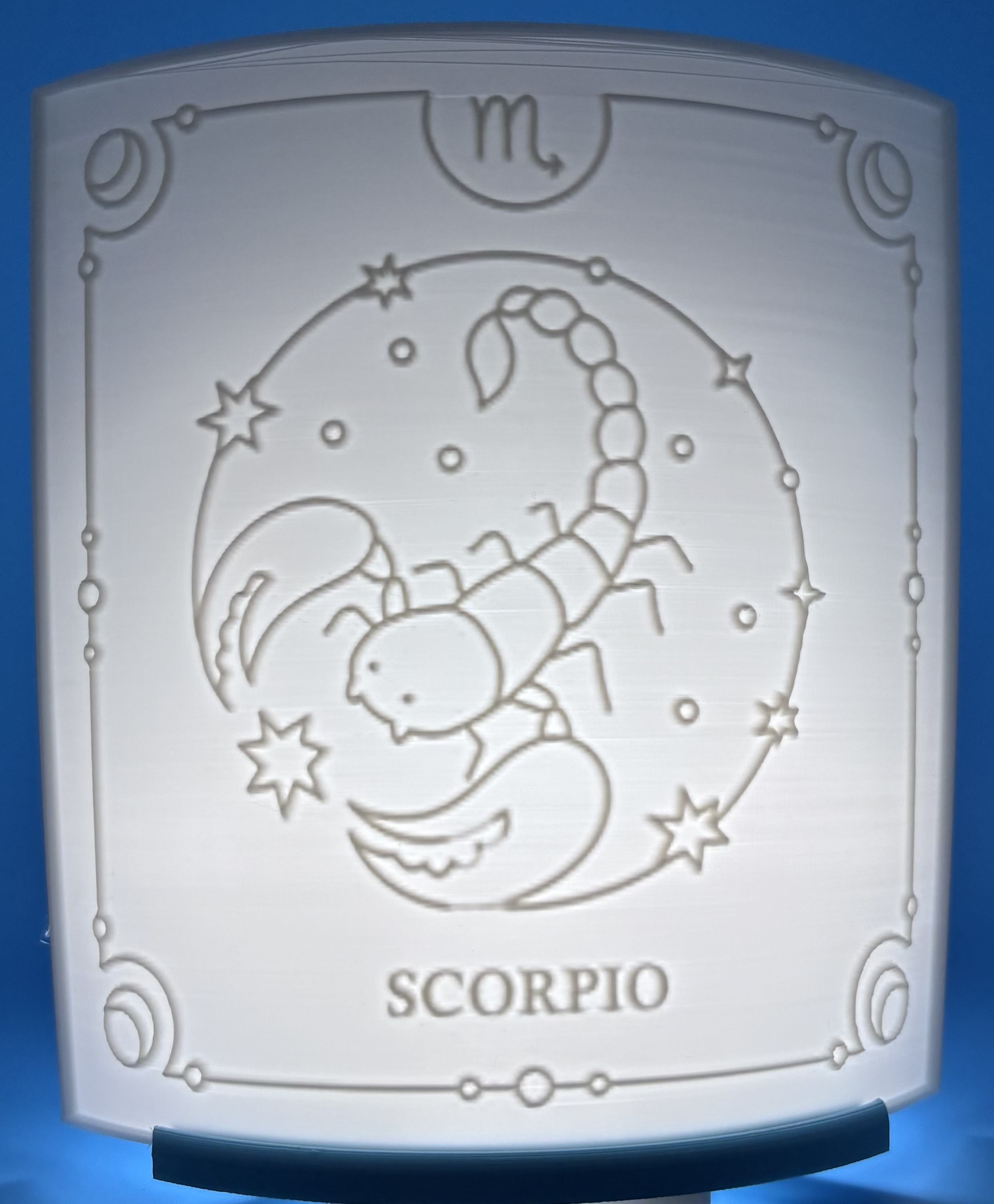 Custom 3D printed lithophane displaying a desk setup with keyboard, controller, and 	workspace items illuminated on a light base