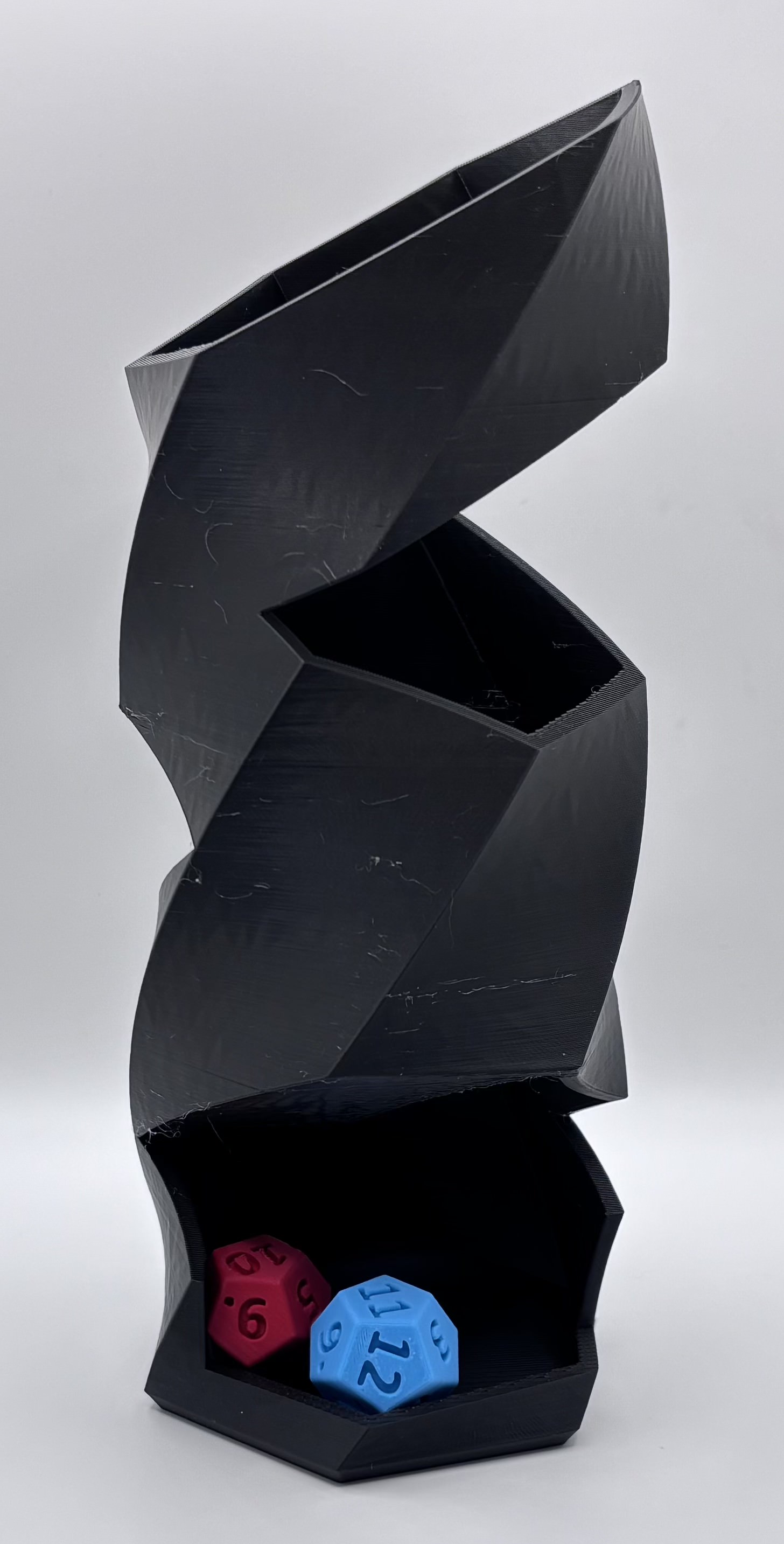 3D printed twisted dice tower with open dice tray holding a single polyhedral die